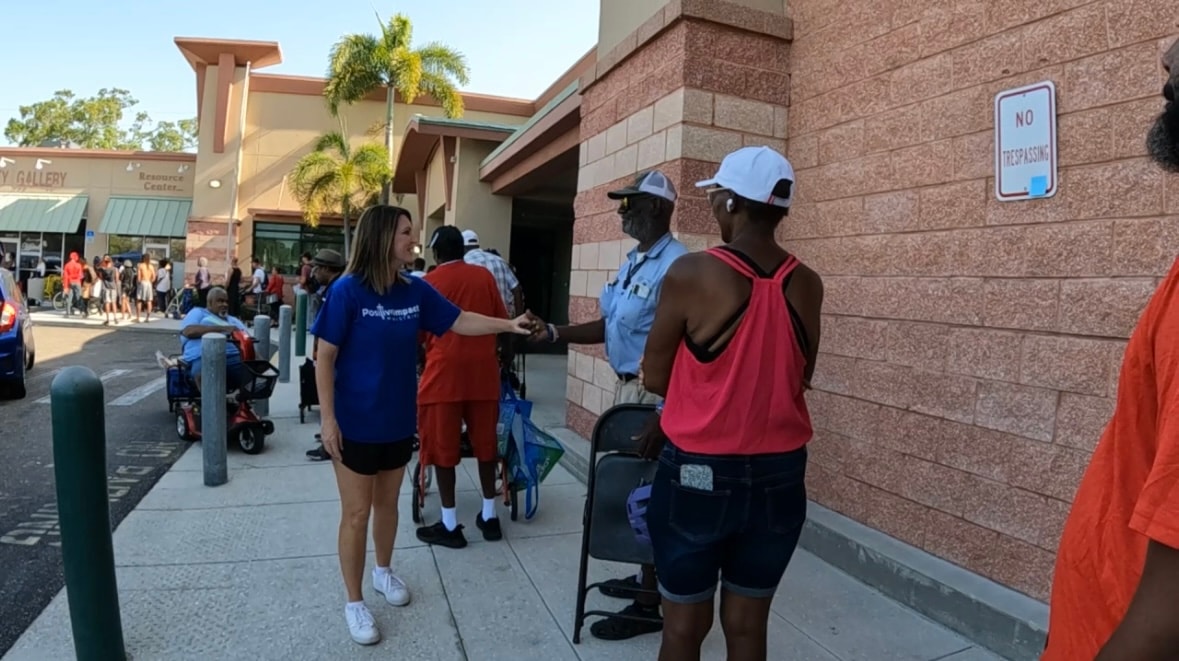 Positive Impact volunteer greeting a neighbor at Tangerine Plaza