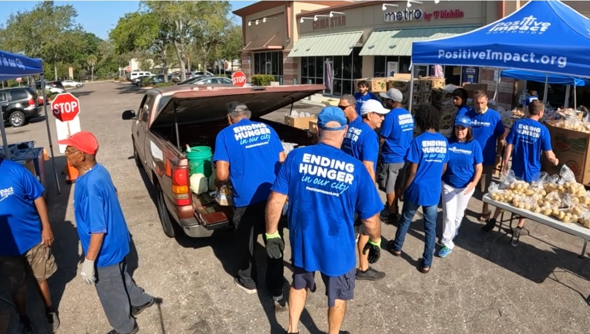Volunteers in Ending Hunger shirts unloading a truck at the distribution site