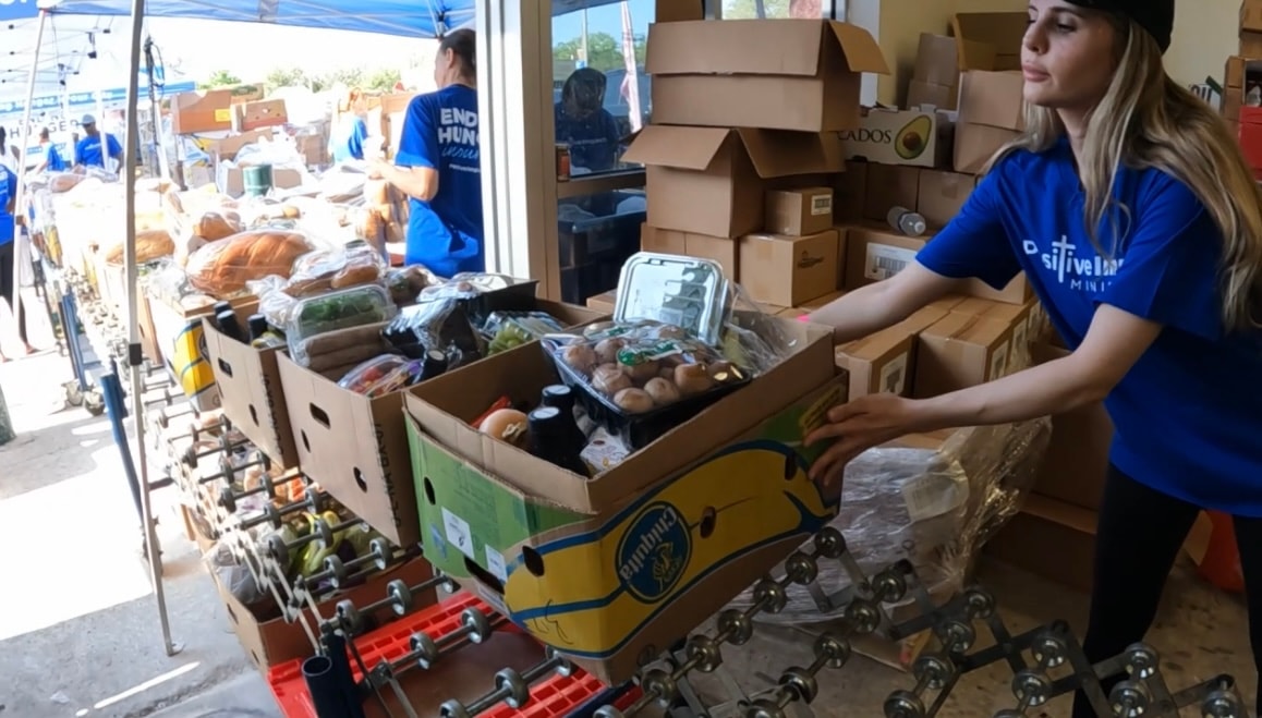 Volunteer sorting boxes of fresh produce inside the distribution center